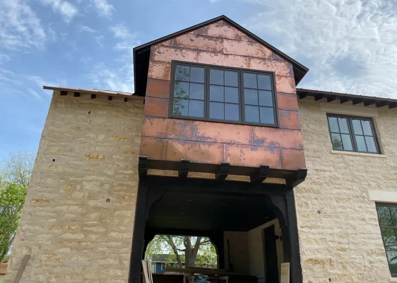 Copper metal panel facade on a stone building for Roof Repair in Dolton